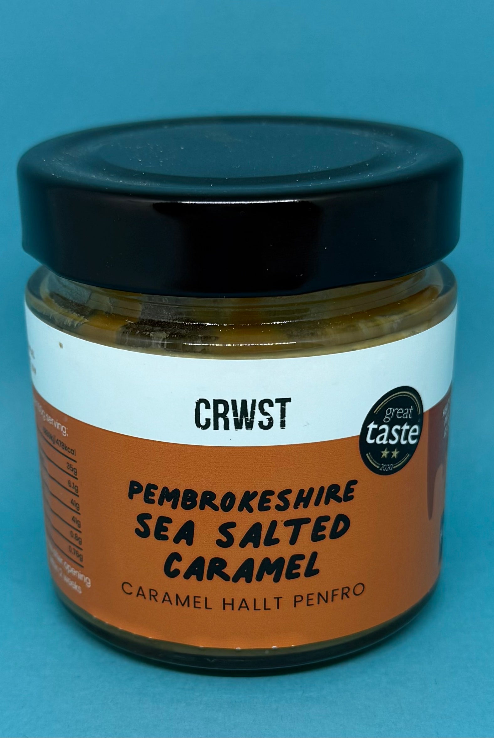 Bluebells and Thyme Jar of Pembrokeshire Sea Salted Caramel with a black lid on a blue background