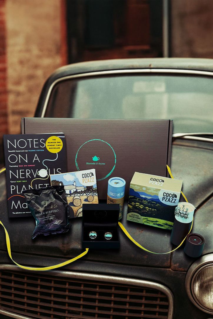 Vintage car bonnet holds 'Just Because' gift box from Bluebells & Thyme, items neatly arranged.