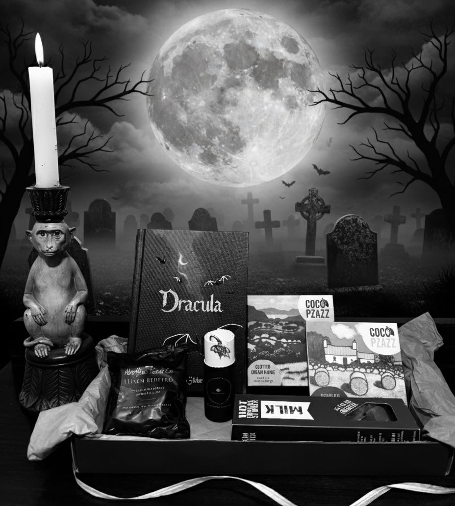 Spooky Halloween-themed gift set from bluebells and thyme with 'Dracula' book, candy, and decorative items against a moonlit cemetery background.