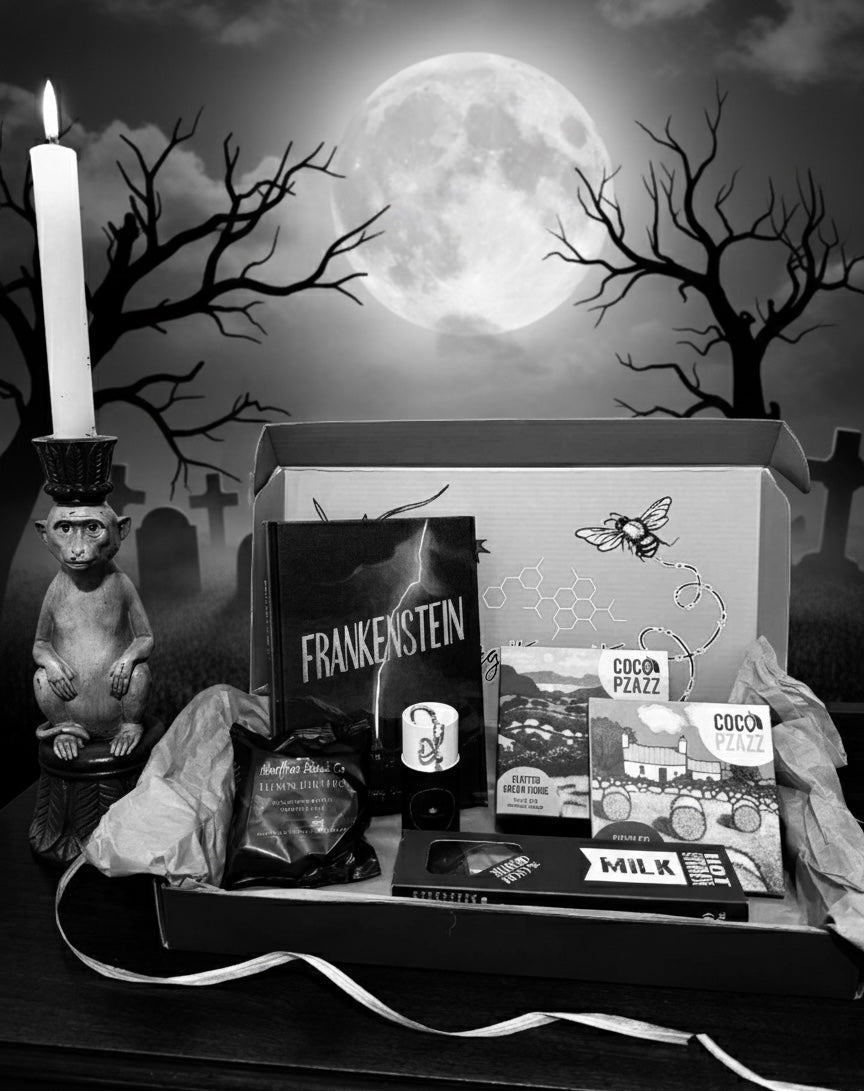 Halloween-themed gift box from bluebells and thyme with Frankenstein book and a candle in front of a moonlit sky.
