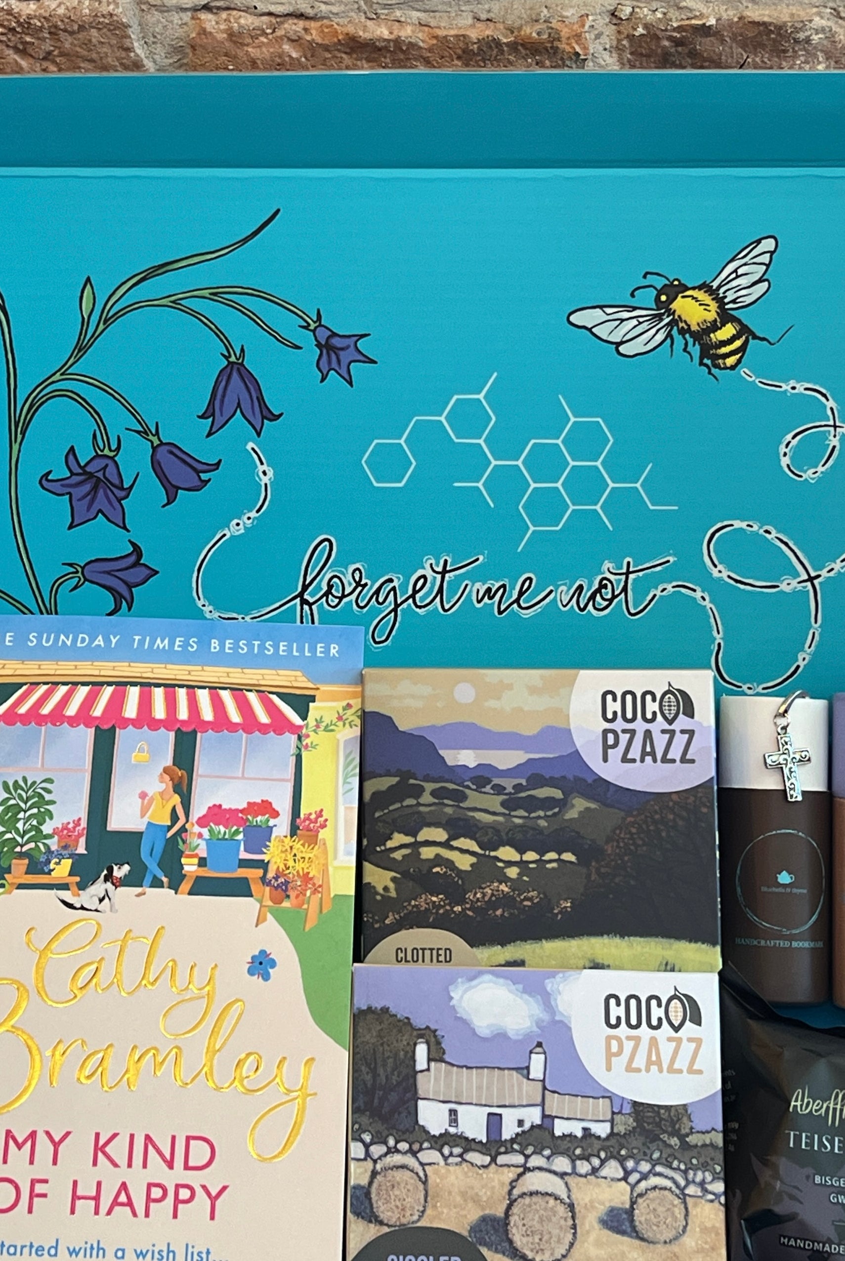 Letterbox Gift box from bluebells and thyme with books, handcrafted bookmark and artisan food and on a wooden surface