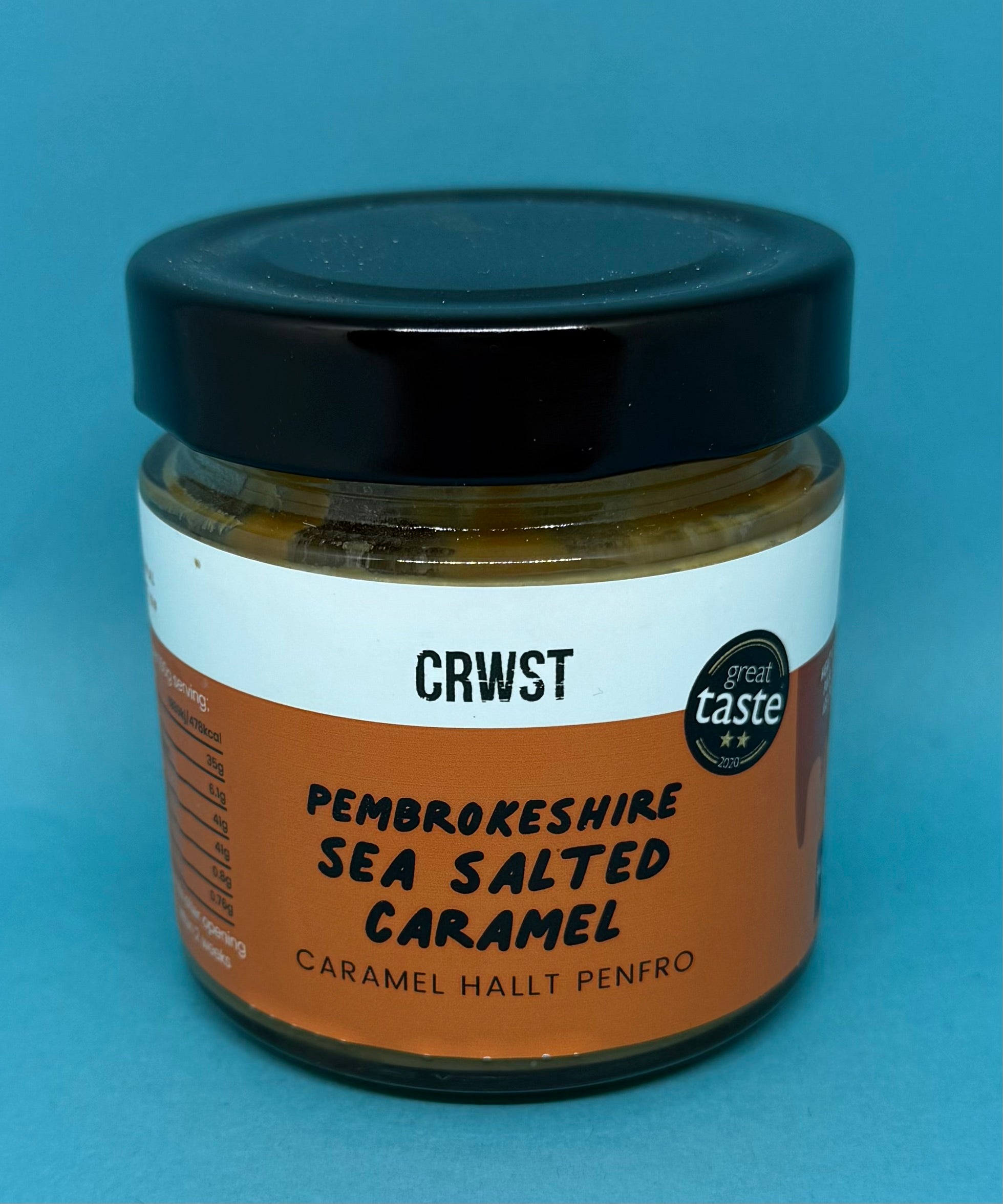 Bluebells and Thyme Jar of Pembrokeshire Sea Salted Caramel with a black lid on a blue background