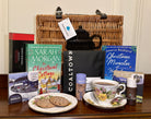 Bluebells and Thyme Wicker Hamper basket with books, a teacup, cookies, and a vintage china on a wooden surface.