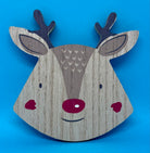 Wooden reindeer head coaster decoration on a blue background